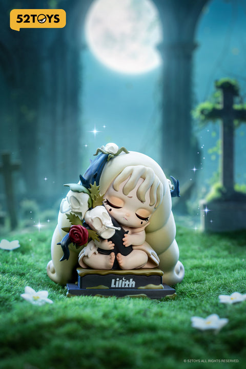 Close-up of the “Hell’s Flowers” figure from 52TOYS’ Lilith: The Century of Mary series. The character sits barefoot in a serene graveyard under moonlight, with eyes closed in quiet sorrow. Her pale hair is adorned with dark blue ribbons and flowers, and she clutches a bouquet of skeletal blooms with a red rose. Resting on a base labeled “Lilith,” the figure conveys themes of mourning and beauty in death, surrounded by soft grass and delicate white petals.