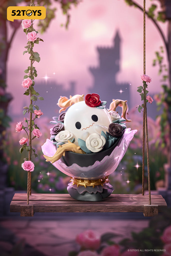 The “Ghostly Bouquet” figure from 52TOYS’ Lilith: The Century of Mary series features a round, ghost-like character with a worried expression nestled among sculpted roses in shades of red, white, and black. It sits inside a black bowl with a delicate pink glass-like flower base and gold detailing. Two pale limbs hang limply over the bowl’s edge. The entire piece rests on a swing adorned with climbing pink roses, set against a dre