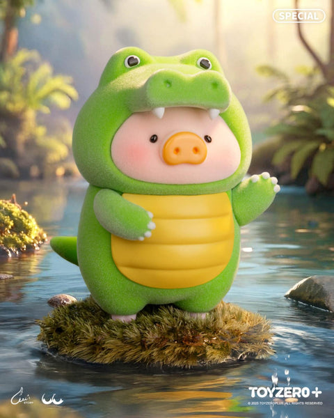 LuLu the Piggy in a bright green crocodile costume with big teeth and yellow belly, standing on a mossy rock floating in a river.
