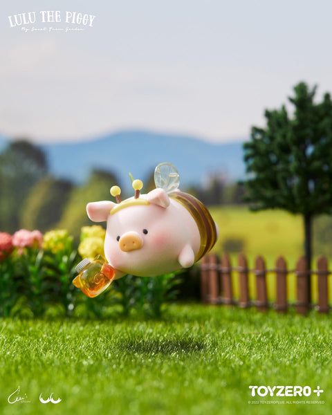 A flying LuLu piggy in a translucent yellow bee suit with wings, holding a small jar of golden honey.