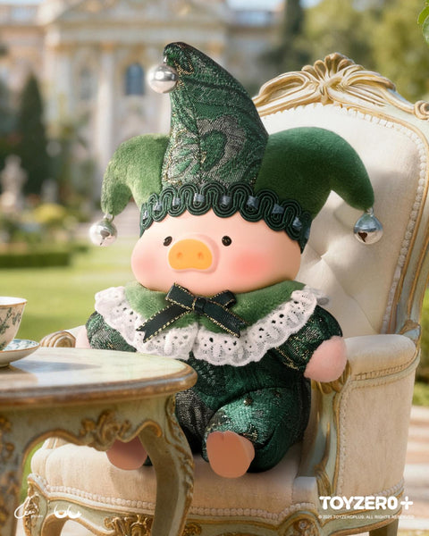The "Embrace U" green jester plush, featuring moss-green velvet textures and ornate lace collar details, sitting in an garden-view sunroom.
