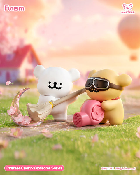 A tan Maltese bear with a mustache and goggles holds a pink leaf blower, while a white Maltese bear stands nearby smiling. Cherry blossoms swirl playfully around them in a cheerful spring setting.