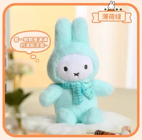 A pastel green plush bunny wearing a fluffy macaron-style suit with tall ears and a smooth white face. The figure features simple black dot eyes, an X-shaped mouth, and a light green textured scarf, creating a fresh, gentle color palette and soft visual balance.