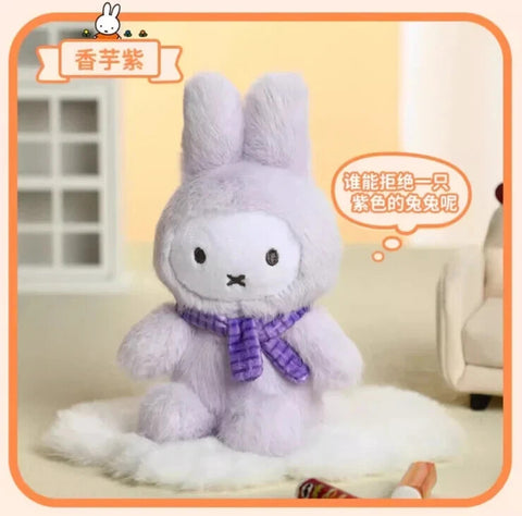 A lavender plush bunny figure wearing a fluffy macaron-inspired outfit with long ears and a compact body. The bunny features a white face, minimal black eyes, and an X-shaped mouth, complemented by a purple scarf that enhances the soft, dreamy color scheme.