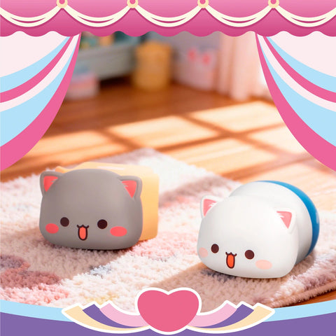 Peach tucked into a blue sleeping bag and Goma peeking out from a small yellow cardboard box.