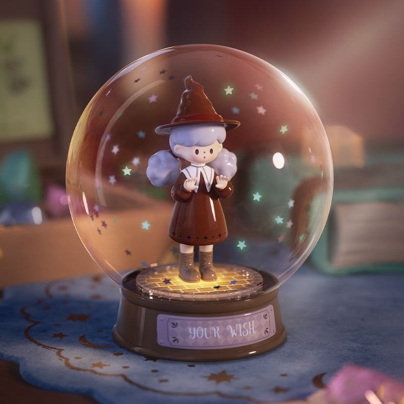 A tiny witch figure stands within a clear snow globe, bathed in amber light and surrounded by stars. Her calm expression and delicate pose give the sense of a wish preserved in glass, glowing softly as though the universe itself listens to her quiet spell.