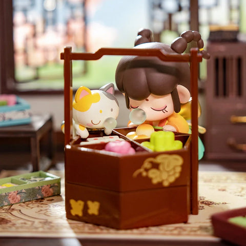A playful collectible figurine from the "Nanci Blooming Girl" series features a girl with braided buns secretly snacking on desserts from an elegant wooden food box. Her eyes are closed in delight as she enjoys a sweet treat, while a mischievous cat beside her also indulges, both blowing bubblegum bubbles. The intricate interior setting, with traditional Chinese furniture and delicately crafted pastries, adds warmth and charm to this whimsical and nostalgic scene.