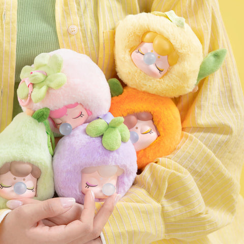 A full display of the Nanci Fruit Mood plush blind box series featuring fruit-themed designs: strawberry, orange, lemon, apple, pear, mangosteen, and a secret cherry chaser. Each fuzzy plush has closed eyes, bubblegum bubbles, and leafy details, arranged for colorful presentation.
