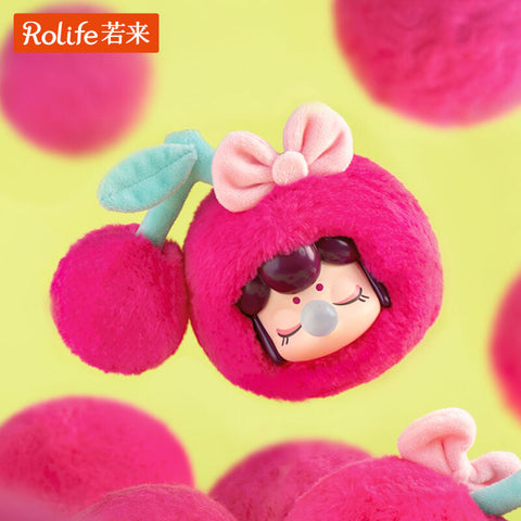 A Nanci Fruit Mood plush styled as cherries, with a bright magenta fuzzy round body and an added cherry stem accessory. A pink bow tops the look, while the figure’s face inside rests with closed eyes and a bubblegum bubble. Whimsical and rare, it’s the secret chaser of the set.