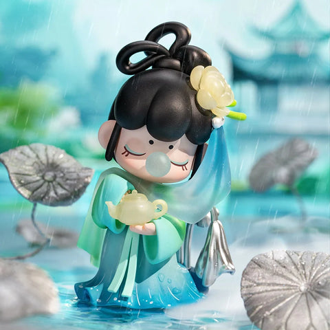 Nanci standing on water dressed in a blue robe holding a tea pot.