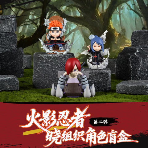 Pain, Konan, and Nagato figures are shown together. Pain performs a jutsu with grey rock effects rising, Konan spreads white paper wings, and Nagato sits with mechanical extensions attached, all standing out with dramatic Akatsuki details.