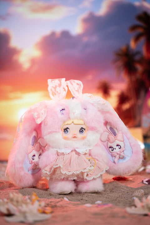 Secret plush character styled in luminous pastel tones with soft glowing highlights, featuring a fuzzy hood and intricate costume details. The figure’s glossy eyes, layered fabrics, and radiant color palette suggest a rare glowing weather moment beyond the standard series.