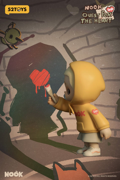 A figure from the 52TOYS Nook “Quest for the Heart” blind box series features a blond child in a yellow hoodie labeled “Lost” and “Nook,” painting a dripping red heart on a shadowy wall. The figure holds a paintbrush while surrounded by mysterious silhouettes, including a fox and bird, in a dimly lit, sketchy forest backdrop.