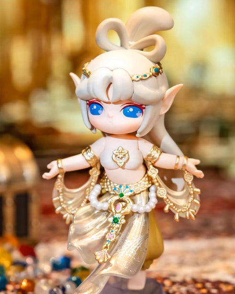 The Western Treasure Merchant Suri with white hair, bright blue eyes, and an ornate golden outfit adorned with blue and green gems.