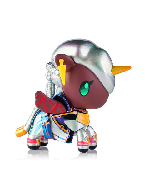 A Unicorno styled as Ambessa stands with a silver chrome helmet, teal eyes, and multicolored armor mixing red, blue, white, and gold elements. The figure has a metallic tail piece, bold yellow earpiece accents, and a bright orange horn. Glossy surfaces create shifting reflections across the body.