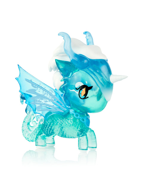 This image shows the Tokidoki Unicorno Mystical Dragon “Aquatic Dragon,” a translucent turquoise dragon-unicorn figure with scaled texture, icy blue wings, curled tail, white snowy mane, and small white horn. It has bright yellow eyes and stands posed against a clean white background.