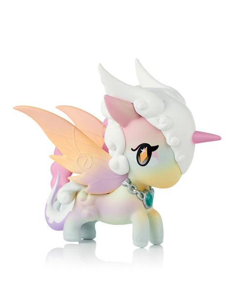 This image shows the Tokidoki Unicorno Mystical Dragon “Prism Dragon,” a pastel rainbow figure blending soft pink, yellow, and blue tones. It has translucent wings, curled mane, white horn, and a teal gemstone necklace. The multicolored gradient body is displayed on a white background.
