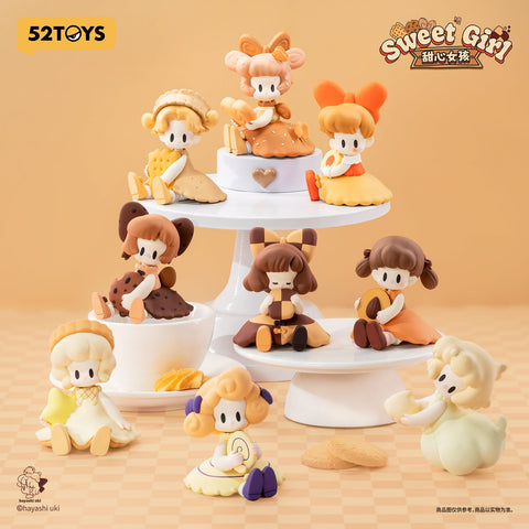 Complete collection of UKI Sweet Girl Series Blind Box figurines displayed on tiered plates. Each pastel doll is styled after cookies, crackers, and biscuits, creating a whimsical dessert table scene.