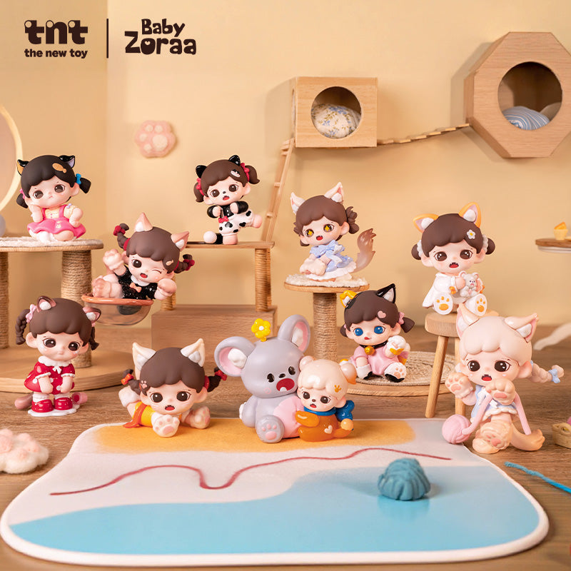 A complete lineup of Baby Zoraa’s Meow Cat Face Mini Series figures is arranged on a beige cat-themed playroom set. Ten cat eared characters in various poses and pastel outfits sit and play among wooden platforms, yarn toys, and a soft mat designed to look like a poolside or beach scene.