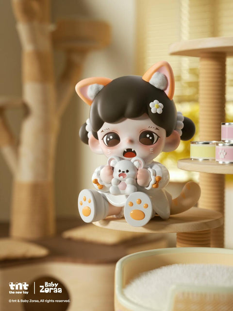 A figure with dark brown hair and orange-tipped cat ears sits on a beige cat tower, holding a white plush toy with pink paws. The design includes paw-print shoes, round eyes, and a daisy hairpin. Warm indoor light fills the cozy background.