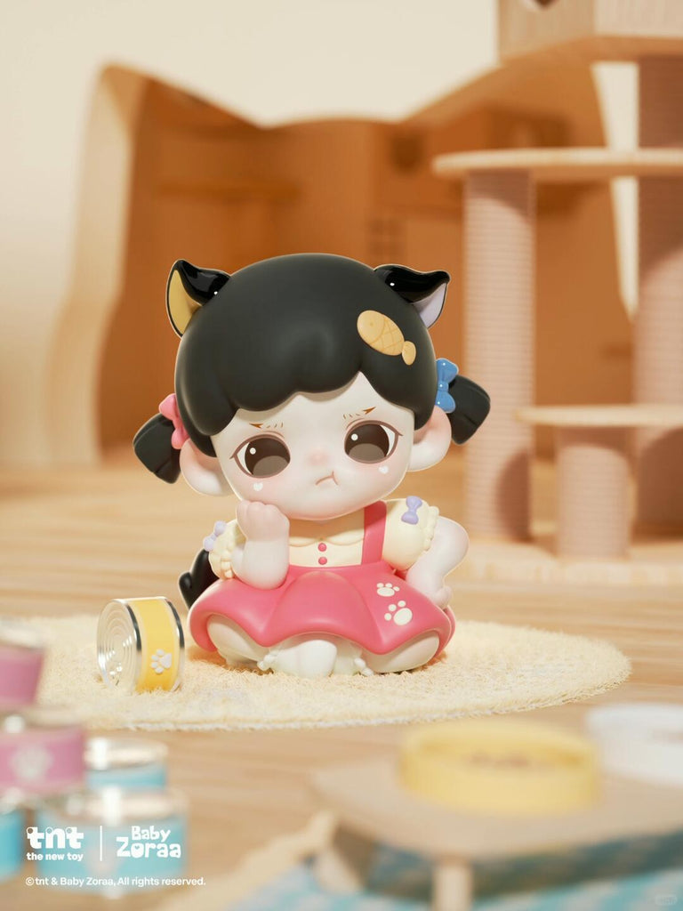 A small blonde cat figure in a yellow outfit hugs a large gray mouse plush with a yellow flower on its head. Both characters sit together on a cat tower perch surrounded by warm morning light and softly blurred background toys.